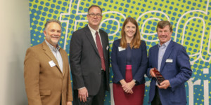 board leadership standing in front of wall with past and current chairs plus Gleaners CEO