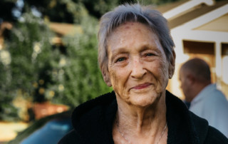 senior woman with grey hair a black jacket and silver necklace