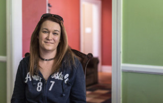 woman wearing blue sweatshirt in front of green and red walls