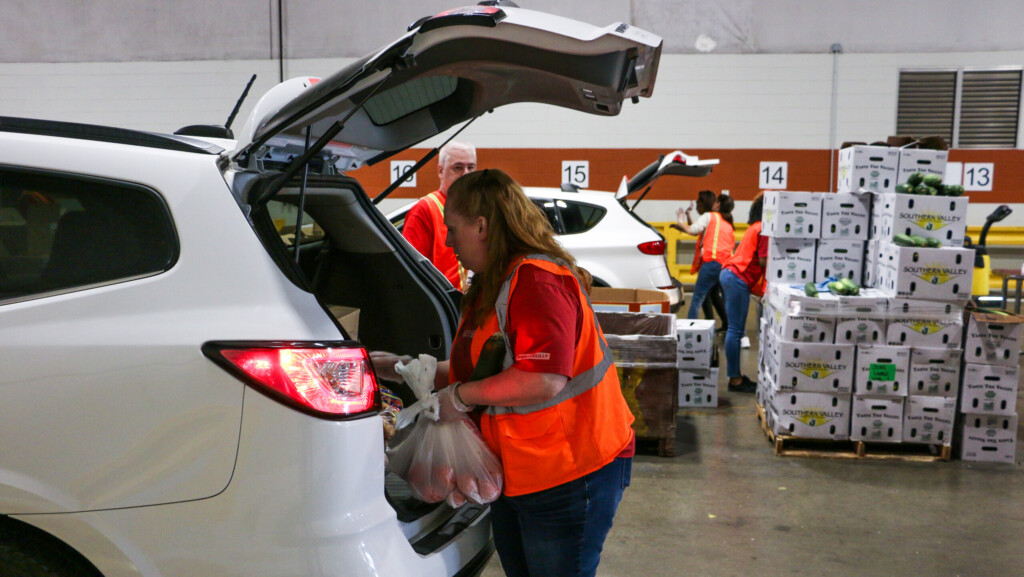 Gleaners volunteers load groceries into cars at the Community Cupboard drive-thru pantry.