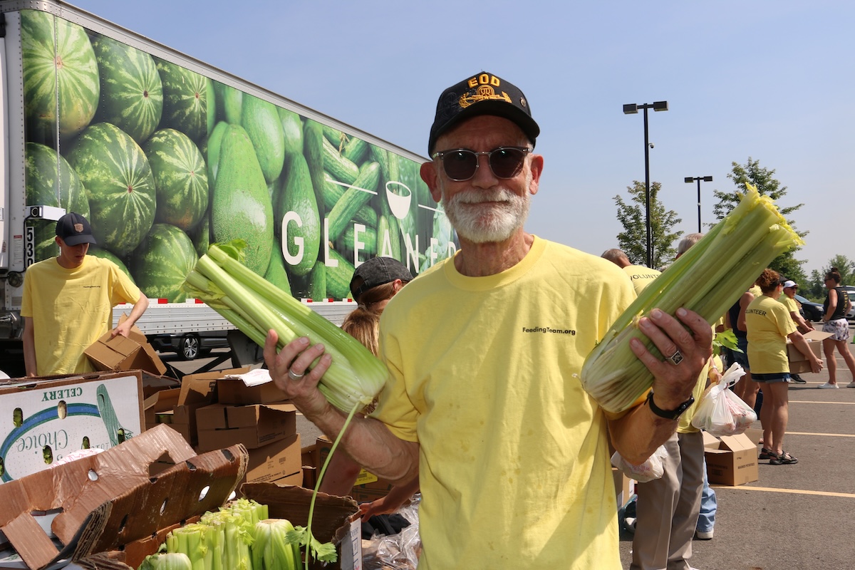 A volunteer with the Feeding Teams helps prepare food for distribution at a Hamilton County mobile pantry.